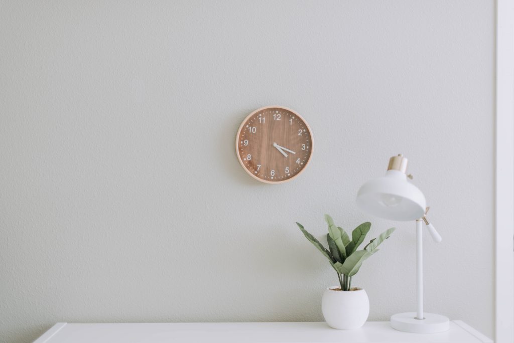 Bureau avec lampe, plante et horloge murale