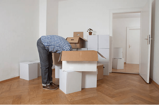 homme avec la tête et les bras dans un carton de déménagement