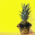 ananas avec des lunettes de soleil sur un fond jaune