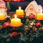 Couronne de Noël en branches de sapin posée sur une table avec des bougies